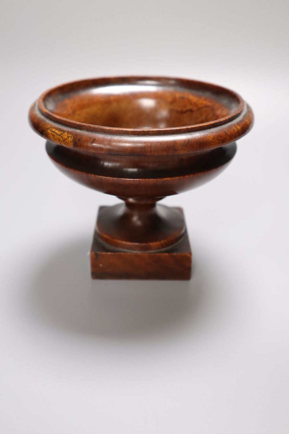 A 19th century turned amboyna urn, 11cm and two late Georgian turned mahogany egg cups, 6.5cm